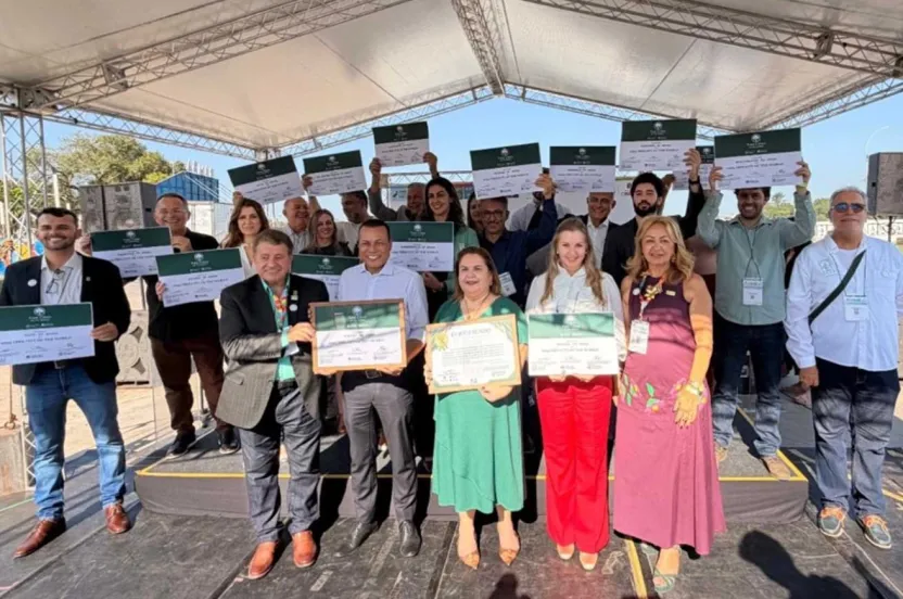 A diverse group of individuals proudly displaying their certificates in a celebratory setting.